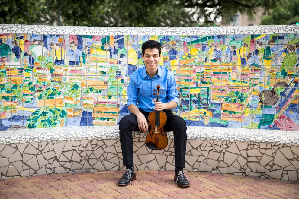 Ruben Rengel sitting on a bench with violin